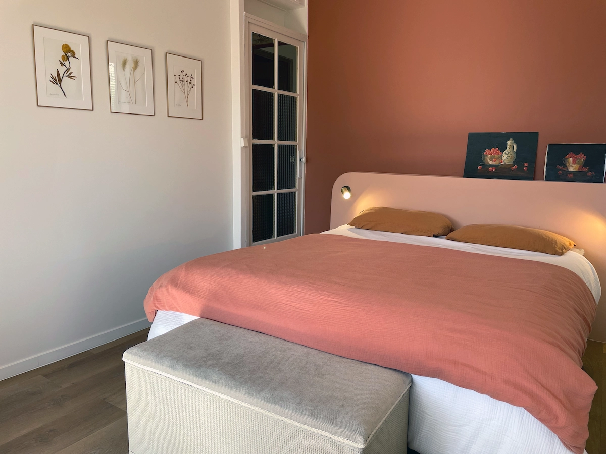 Chambre avec mur terre cuite et cadres botaniques