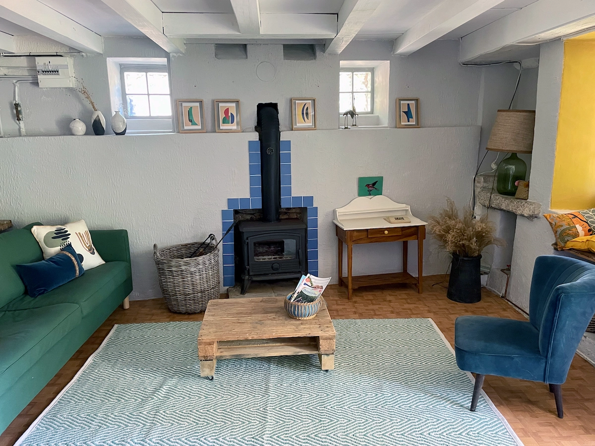 Salon avec poêle à bois et poutres